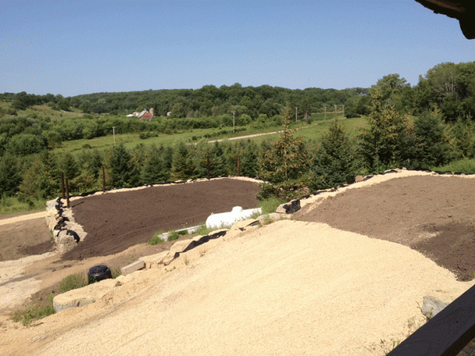 This view shows our garden in the distance.  In the foreground is the drive way and the leveled area where we will plant grass for now, and eventually hope to build a garage.